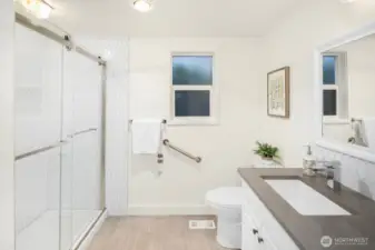 The primary suite features a custom closet system and en-suite bath with an oversized, beautifully tiled shower.