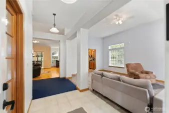 Bright entry opening to a spacious living area with vaulted ceilings, large windows, and a comfortable open layout.