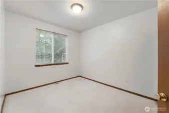 Comfortable bedroom with large window bringing in natural light and peaceful outdoor views.