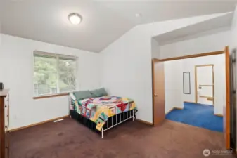 Spacious primary bedroom with vaulted ceiling and direct access to the ensuite bathroom.