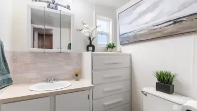 Bathroom with new tile backsplash, lighting and updated toilet