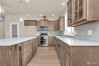 Welcome to the beautiful gathering kitchen featuring maple cabinetry and stainless steel appliances including a double gas oven. Photo from same plan on different lot, finishes and features will vary.