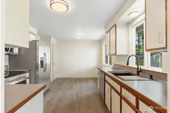 Roomy & bright kitchen features cute eating area next to window.