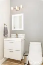 Conveniently located on the main floor, this elegant powder room features a modern vanity, updated fixtures, and neutral tones.