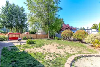 Patio off the family room with stone block lining the garden bed on the fence side.  New fence on the north side of the yard