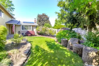 The front yard has lush landscape and spaces for relaxing in privacy