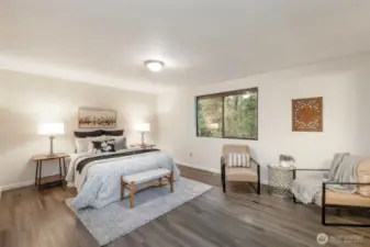 Find the primary bedroom that looks out into the peaceful backyard.