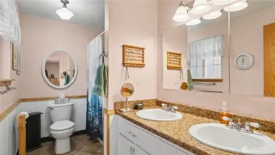 3/4 en-suite bathroom offers dual sinks and ample storage space.