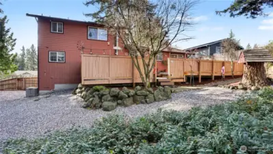 Beyond of the fenced deck, the backyard features walk ways and low maintenance shrubbery.