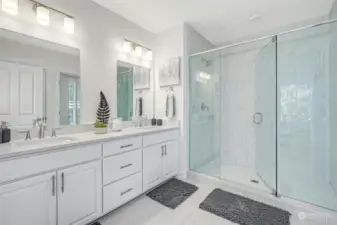Primary Suite Bathroom. Frameless walk-in shower enclosure with double vanity.