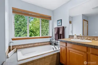 Primary with soaker tub that looks out to trees