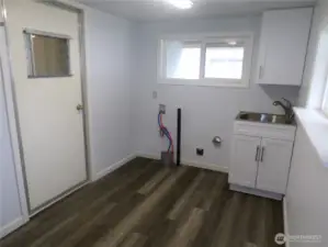 You have entered the laundry room from car port.  The door you see goes into the home.  This laundry room/mud room has enough room for more storage ideas.