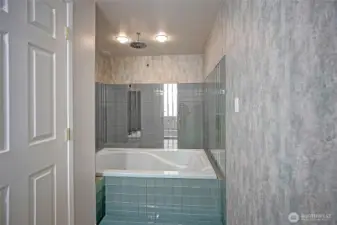 Unit 2 primary bathroom with soaking tub and rain shower.