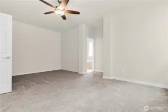 Inviting and spacious primary bedroom with ceiling fan for added comfort.