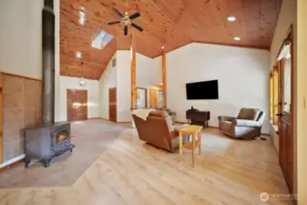 Living room with vaulted ceiling and cozy wood stove.