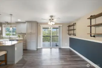 Dining area leads to covered deck overlooking open field