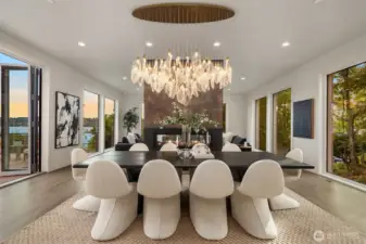 Wall-to-wall windows, operable glass walls, a sculptural chandelier, and a double-sided fireplace set the stage for dining with style and a view.