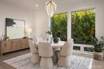 A cozy dining nook bathed in natural light, where floor-to-ceiling windows frame a lush, private green backdrop (not shown-the slider opening on to the main floor entertaining deck)