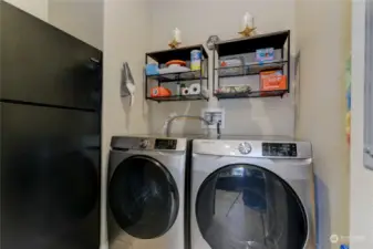 Behind the barn door in the kitchen is this lovely laundry room with additional storage space!