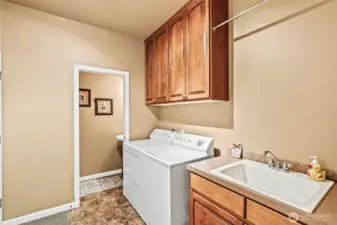 Large laundry with hardwood cabinetry, utility sink plus well-placed half bath for ease of use while working outside in the garage, yard or shop.