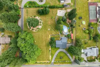 This picture shows the actual full acreage and house sitting on this open aired, garden filled 2 acre lot. On the SW corner of lot is where an ADU or structure can be built. Rightside driveway is owned by this house but back has easement to get access to their property.