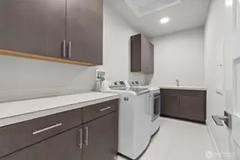 Spacious utility room with plenty of cabinet space, countertop space and sink