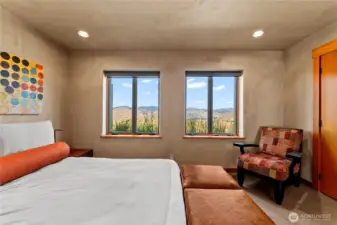 Down a half-flight of stairs, the second bedroom offers ground level views looking over the Pasayten. There is a rather large buck who likes to bed down right up against these windows on hot afternoons.