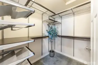 Roomy walk in closet with organizers.