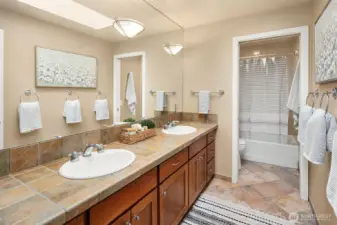 Full hallway bath with dual sinks + separate commode/shower room.