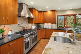 40" Dacor range with 6 burners, dual ovens & handy pot filler faucet. Custom stainless hood finishes the cooking space elegantly.