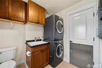 Convenient touches in  the laundry room include a utility sink and half bath,  and access to the outside.