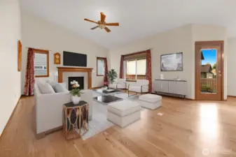 This inviting home features laminate hardwood floors throughout, a spacious and bright great room with vaulted ceilings, a gas fireplace, a ceiling fan, and a glass door leading to a private patio. The kitchen flows seamlessly into the living areas for easy and comfortable living.