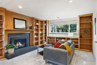 Beautiful library shelving flanks a cozy fireplace in the lower-level rec room.