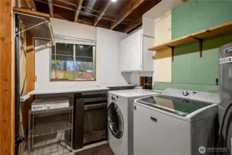 Utility room offers washer and dryer, storage, and a newer water heater.