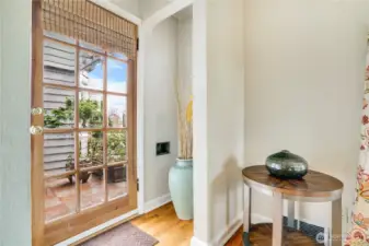 Step inside to warm hardwood floors and a welcoming entry nook with a graceful arched opening, while glass-pane details in the front door bring in sunlight.