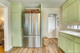 With a newer refrigerator (2022), abundant storage, and durable LVP flooring, this kitchen is designed for ease—plus a Dutch door offers quick driveway access for unloading groceries.