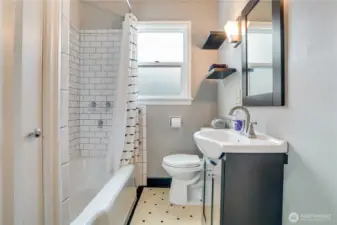 A blend of vintage charm and modern updates, featuring original tile flooring, refreshed surround tile, updated fixtures, and a refinished tub (all in 2022), along with excellent storage.