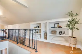 As you ascend into the private primary retreat, built-in shelving adds both character and functionality—ideal for display, storage, or a personal library feel.