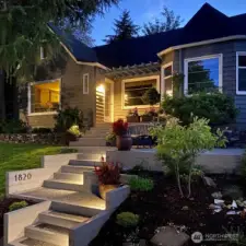 As the day winds down, landscape lighting highlights the beautifully maintained grounds—just moments from campus, neighborhood schools, and the vibrant Proctor District. Thanks for visiting! Photo provided by owner to illustrate seasonal landscaping as it matures and blooms.