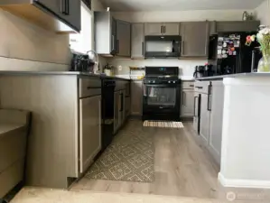 Bright, open-concept kitchen featuring quartz counters, a gas range, and a large island perfect for entertaining! This is truly the heart of the home