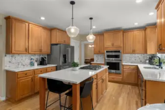 Indulge your culinary passions in a chef's kitchen, featuring a spacious walk-in pantry, tons of cabinet space equipped with custom pullout drawers, a 5-burner gas range and modern stainless steel appliances, ensuring every meal preparation is a delight.