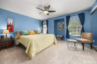The spacious primary bedroom fits a king-sized bed comfortably, with room for side tables, dressers, and more.