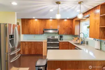 The kitchen features stainless steel appliances and quartz counters.