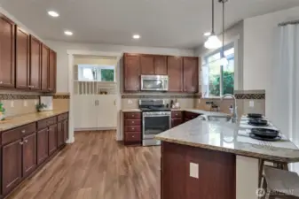 A wonderful kitchen boasts of rich wood cabinetry, granite counter tops with complementing custom tile backsplash.