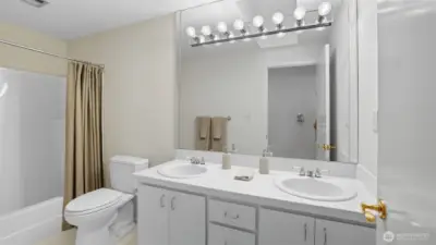 Convenient full bath with double vanity and a combination tub/shower.