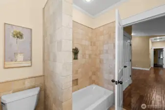 Main floor full bath with natural wood cabinetry and tile surrounds.