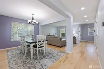 Recessed lighting and light wood floors draw you in to the front living room and dining area.