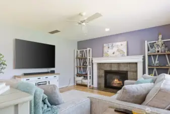 Colors and style continue into this family room, including the accent wall and stately mantle.  Ceiling fan allows the cool air or heat to be effectively distributed for extra comfort!