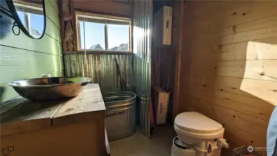 Bathroom with composting toilet and when water is hooked up there is a propane water heater.