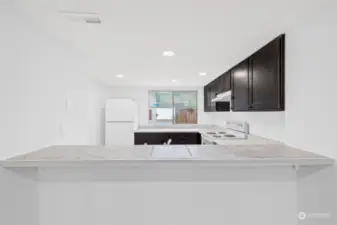 Looking at the kitchen from the dining area.  There is a bar that would fit 3 or 4 barstools easily!